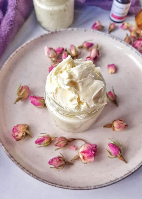 After Sun Moisturizer, a jar of homemade after sun lotion on a white plate with dried rose buds. 